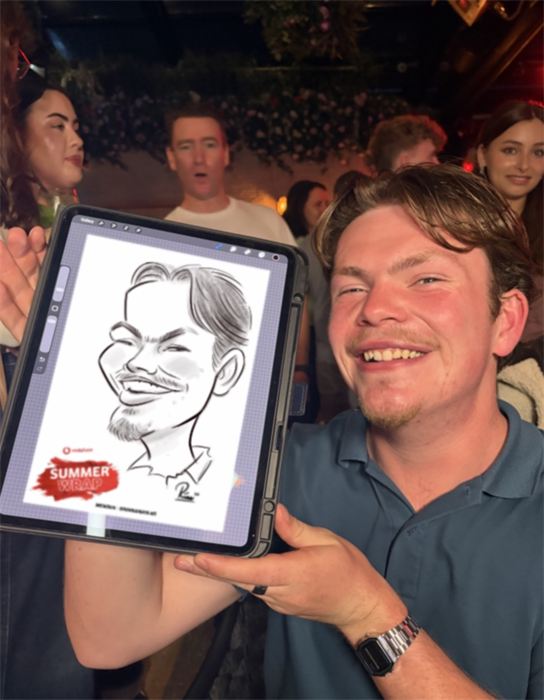 Laughing guest holding up his live caricature drawn on an iPad at a summer party