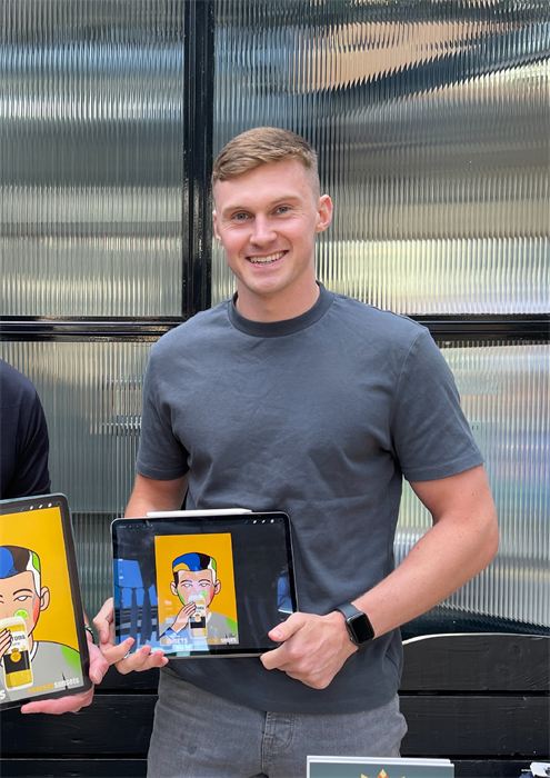 Rían smiling and holding up a live caricature on his iPad at an event