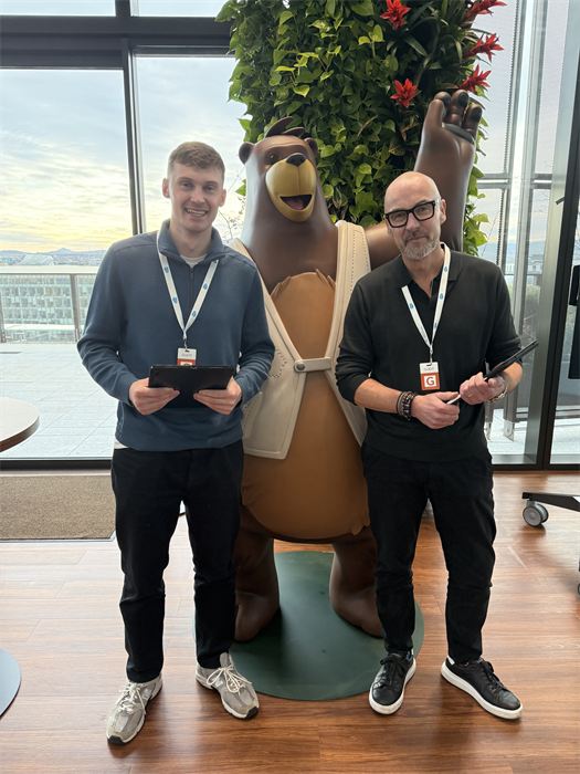 Rían and a colleague holding their iPads at a corporate event