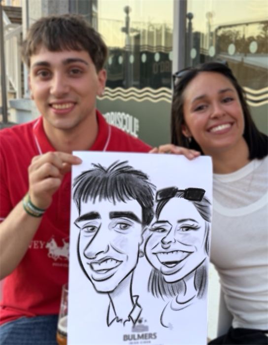 Couple holding their hand-drawn paper caricature